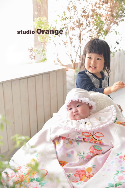 奈良市のフォトスタジオ、スタジオオレンジで撮影。産着をかけた女の子と、お姉ちゃんの2ショット。