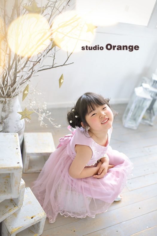 奈良市のフォトスタジオ、スタジオオレンジで撮影。ピンクのドレスを着てカメラを見上げる女の子。