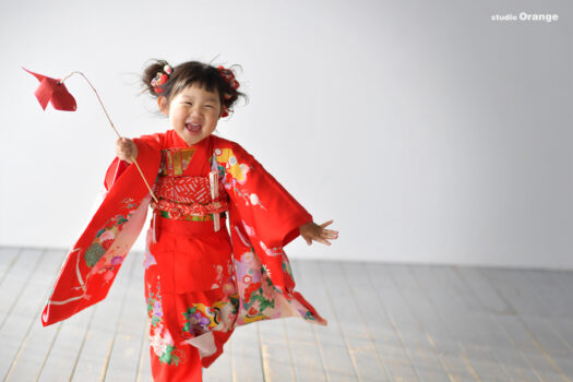 奈良市のフォトスタジオ・スタジオオレンジで撮影したし七五三前撮り撮影写真　3歳女の子　赤色の着物　風車