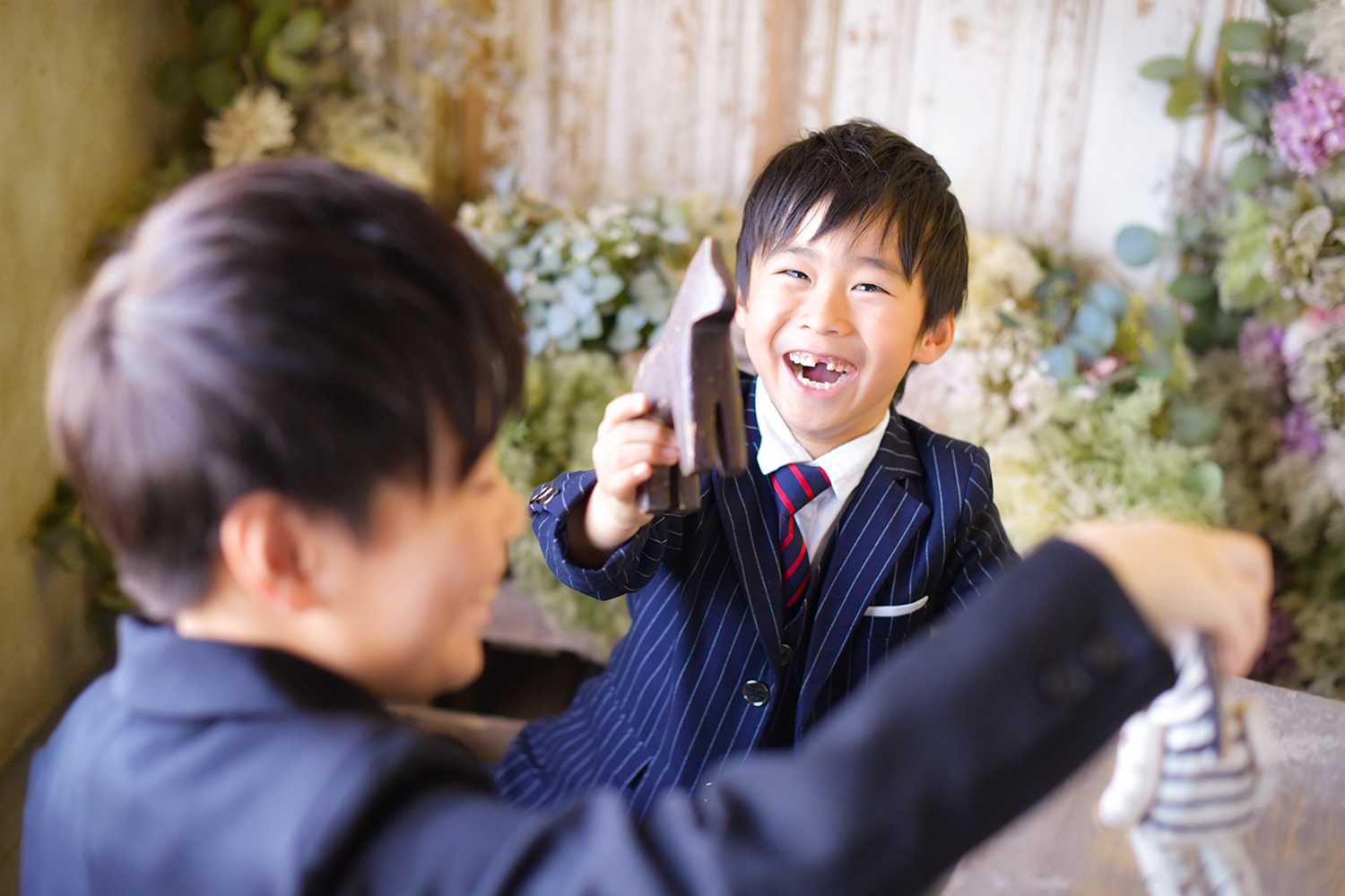 楽しそうに笑うスーツを着た6歳男の子