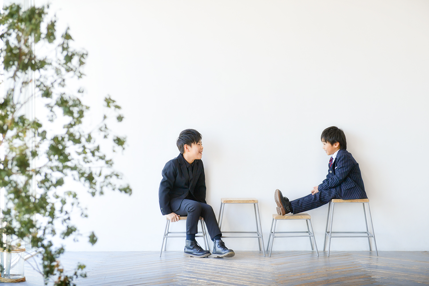 スーツを着て椅子に座っている兄弟