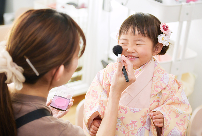 七五三の3歳女の子がチークを塗ってもらっている