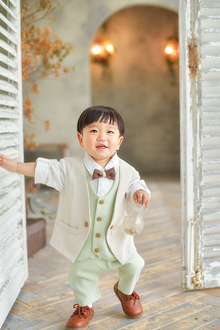 ドアを開けるタキシードをきた男の子