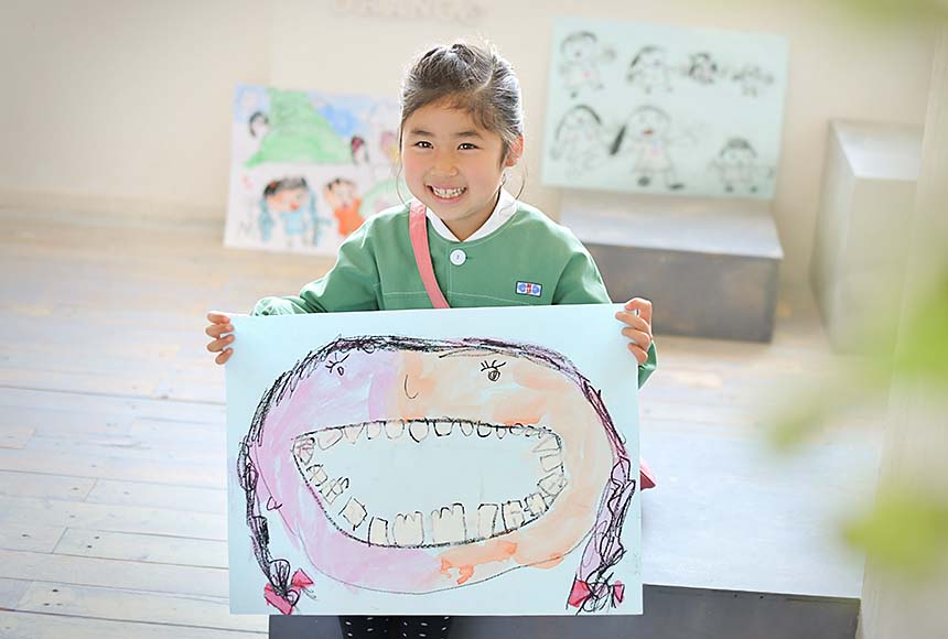 保育園で描いた絵を持った女の子