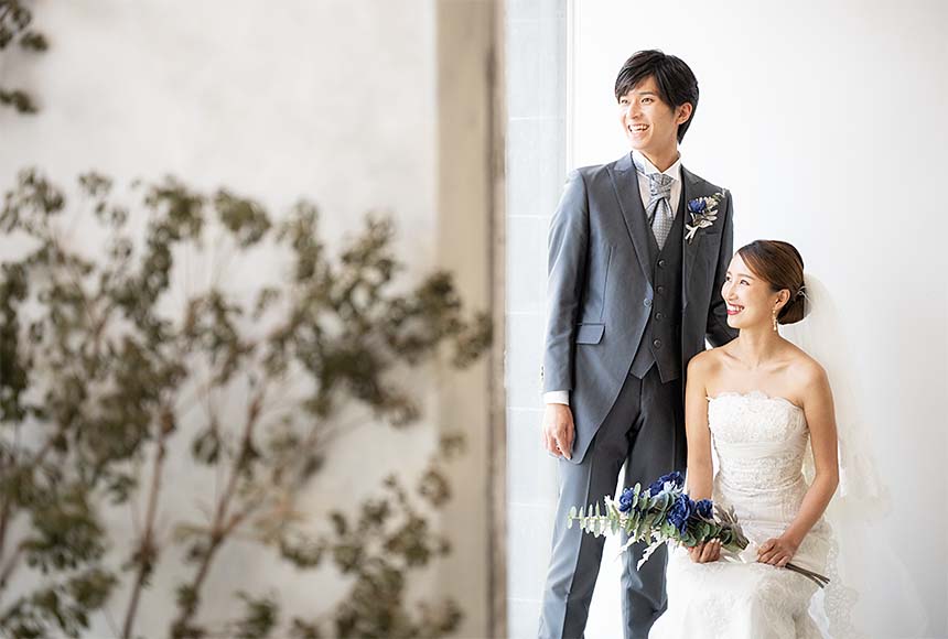 ブーケをもつ新婦のそばに立つ新郎