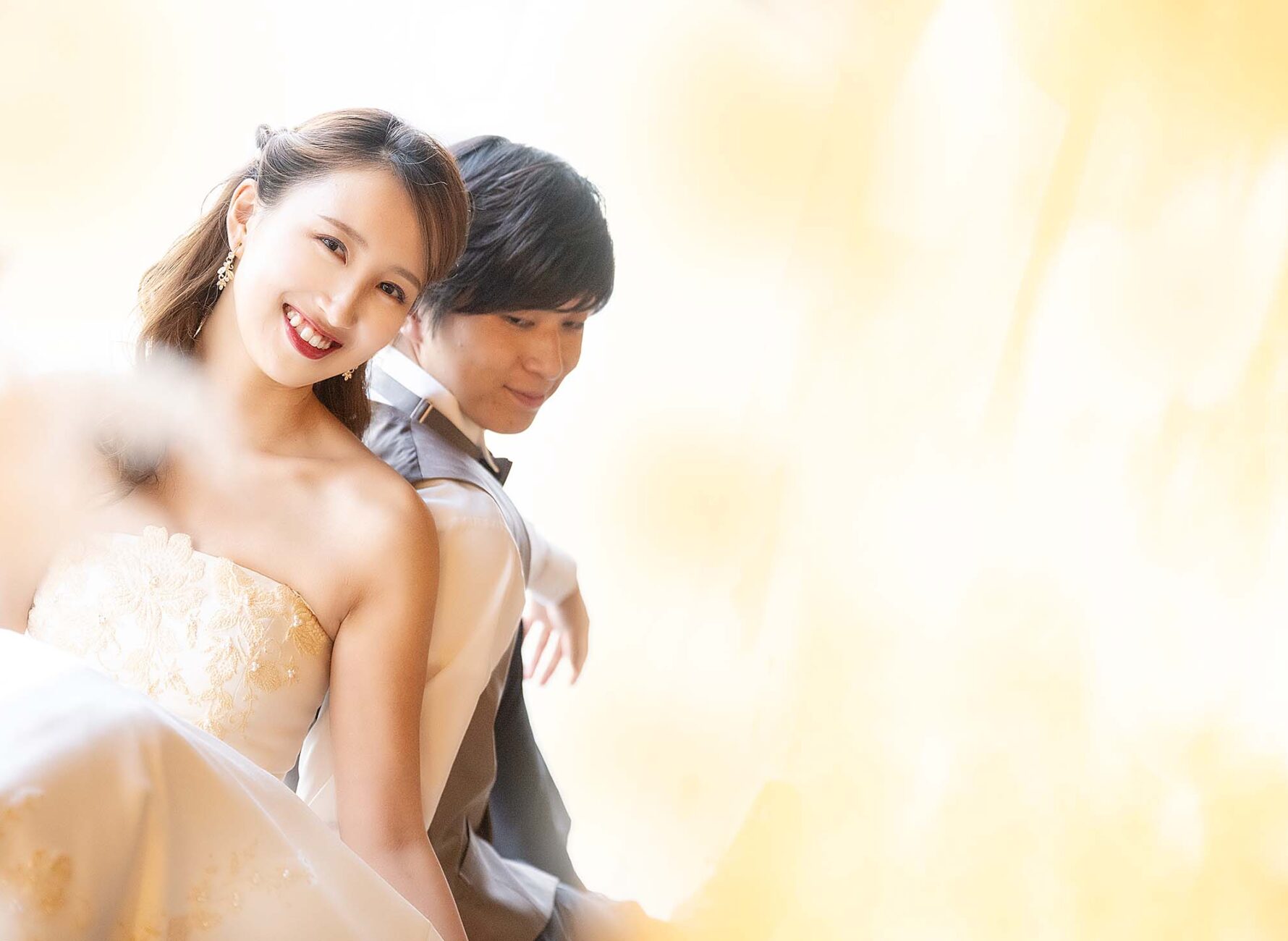 新郎と背中を合わせて座るウェディングドレスを着た新婦