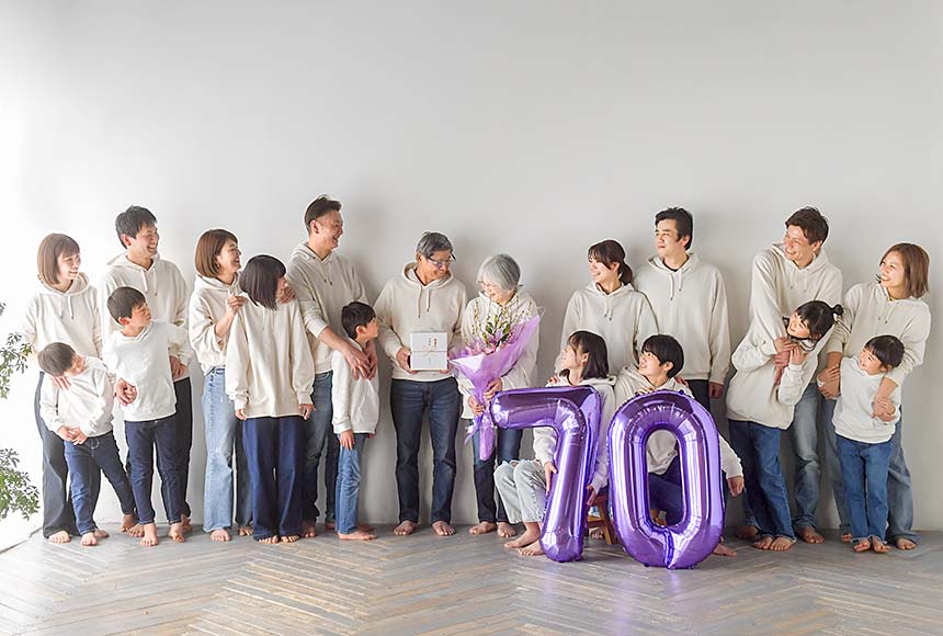 お揃いの白パーカーを着て17人で祖母の70歳のお祝いをする家族