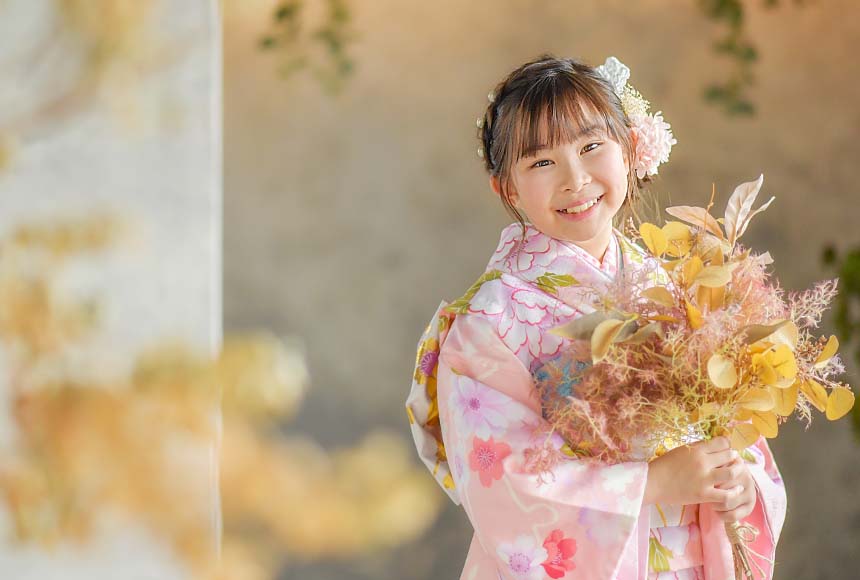 ピンクの着物を着て、ブーケをもつ女の子