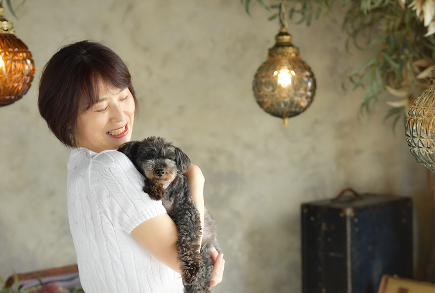 黒のトイプードルを抱っこする女性