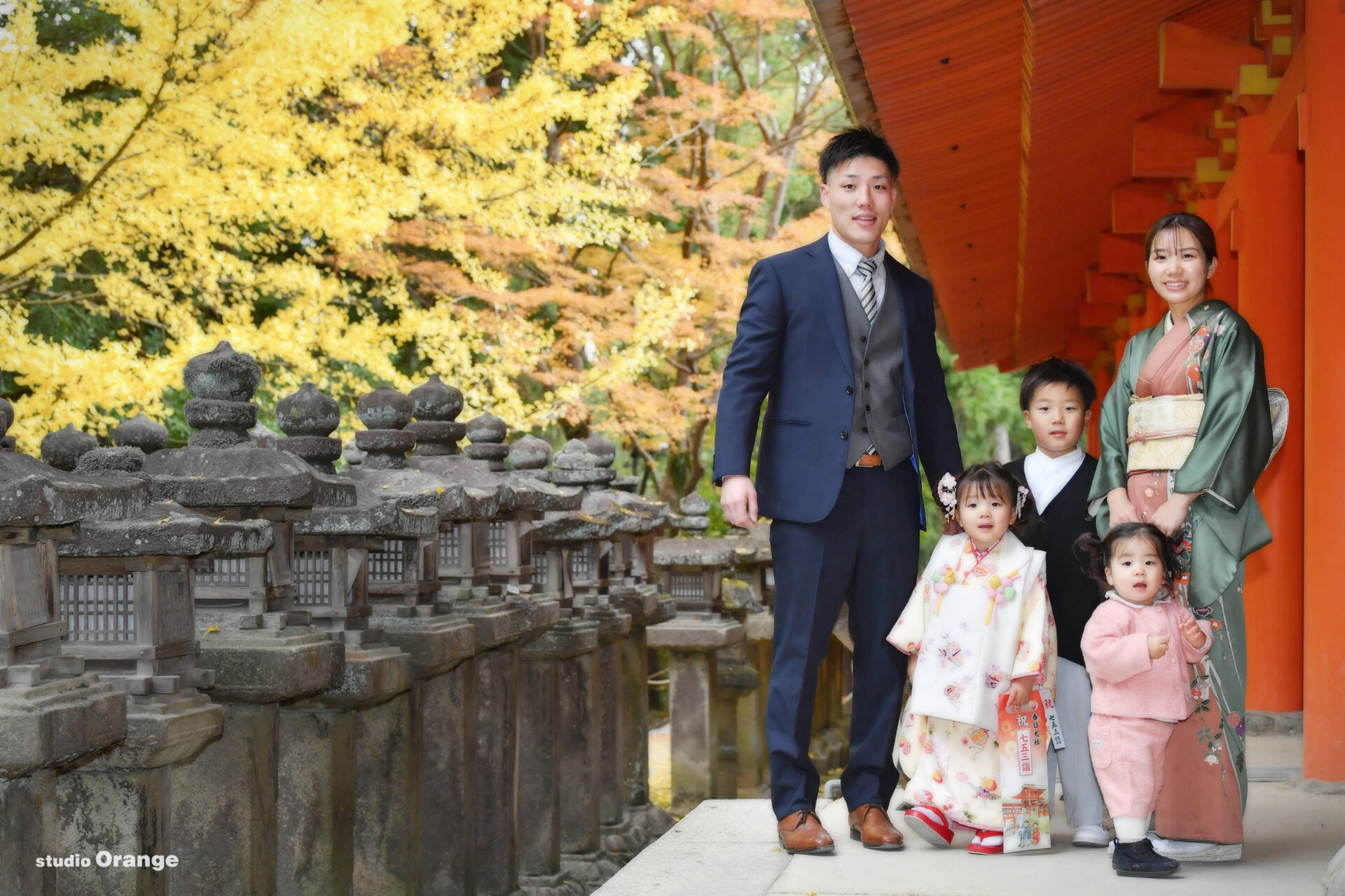 春日大社で3歳女の子の七五三撮影　黄色い着物の七五三写真　紅葉と一緒に家族写真
