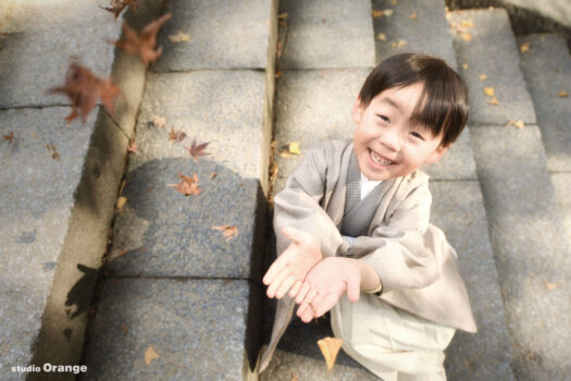 春日大社で5歳男の子の七五三撮影　茶色い秋色の着物の七五三写真　紅葉と一緒の写真
