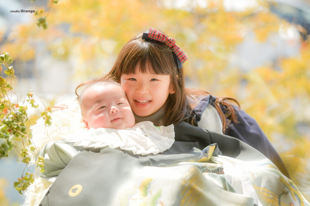 赤ちゃんと女の子が笑顔でこっちを見ている写真