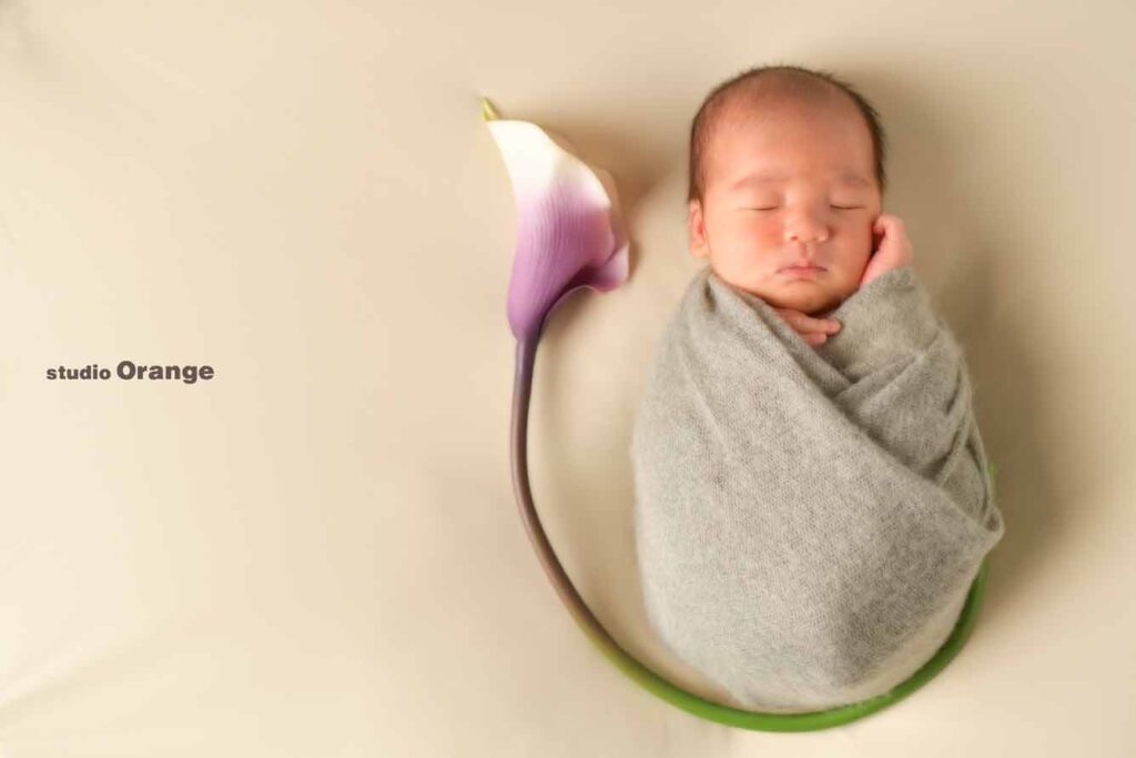 グレーのおくるみに包まれたニューボーンフォト