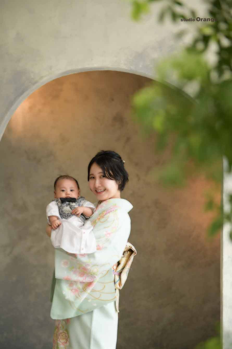 お宮参りの赤ちゃんを抱っこしている訪問着を着たお母さん