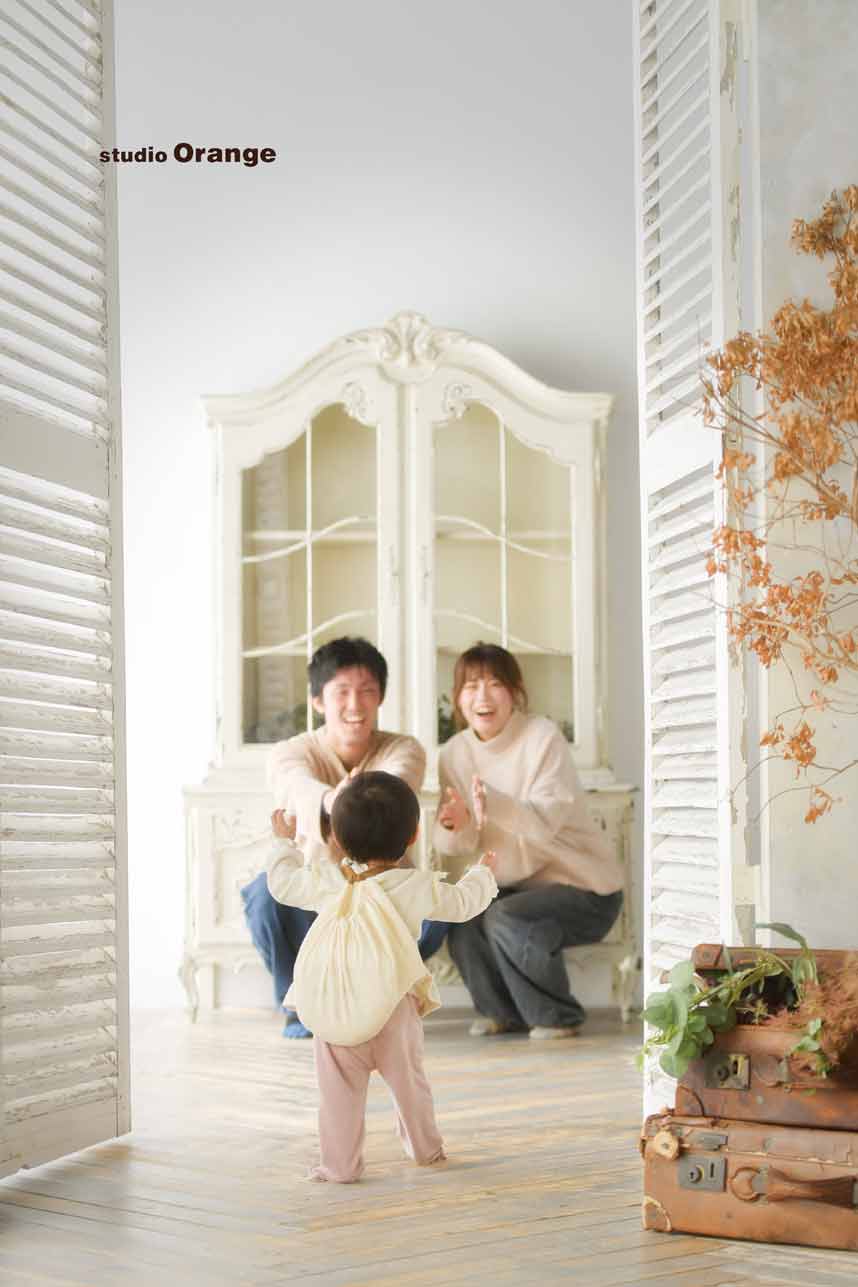 お誕生日撮影で一升餅を背負った1歳の女の子がパパとママのところへとヨチヨチ歩きしている様子