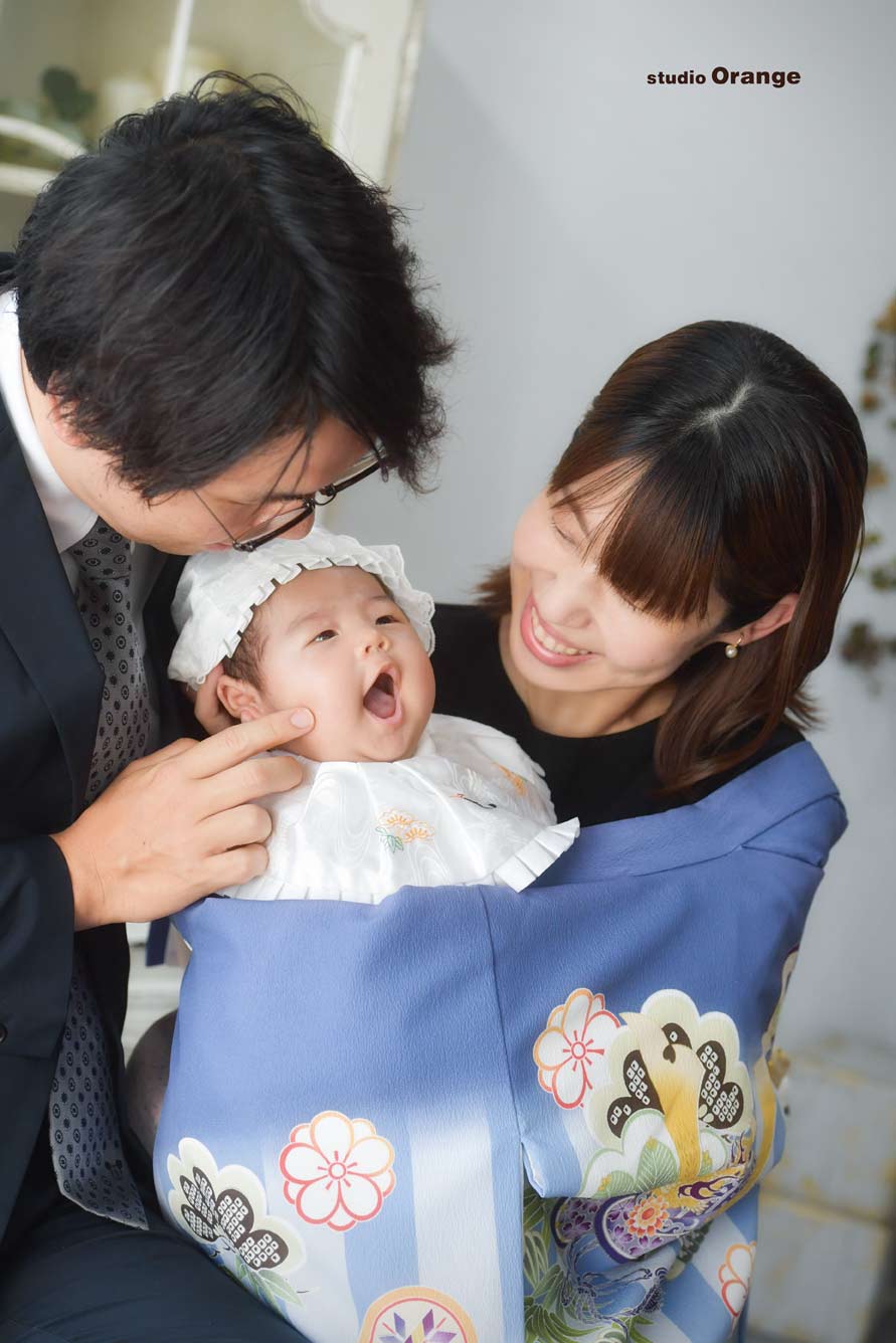 お宮参りで赤ちゃんをツンツンするお父さん