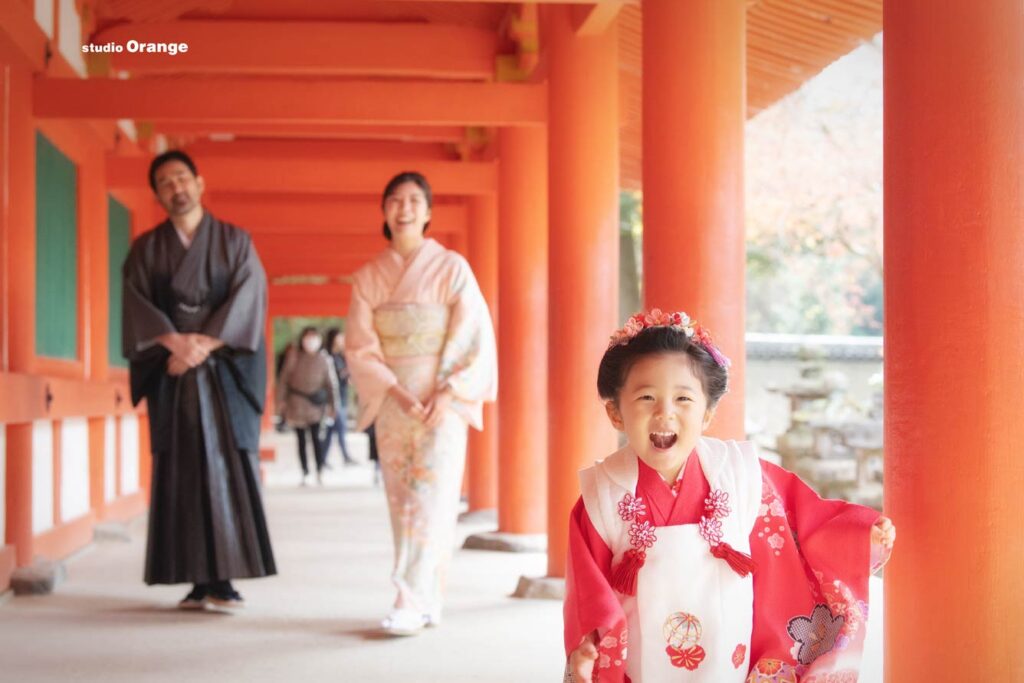 春日大社の回廊を走る七五三着物を着た日本髪の3歳女の子